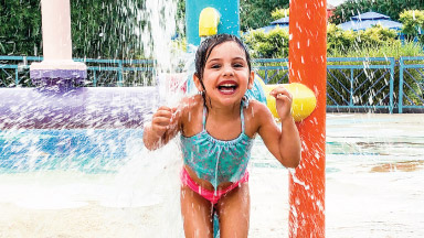 Girl getting splashed by water at Lil' Surfers Splad
